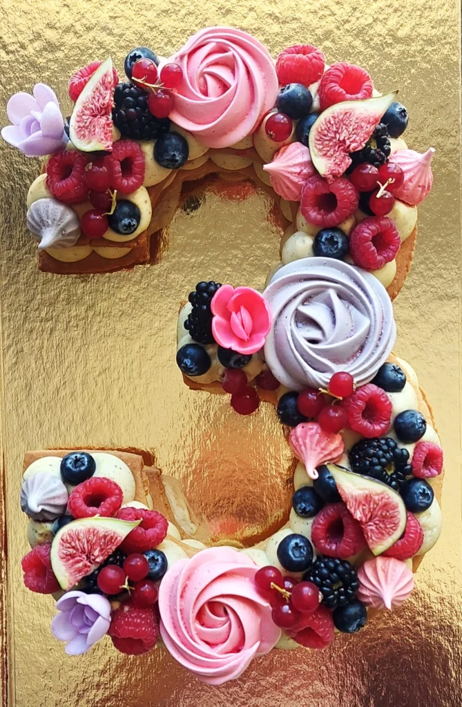 Un gateau biscuit garnis number cake Vanille/Fruits-rouges en forme de 3