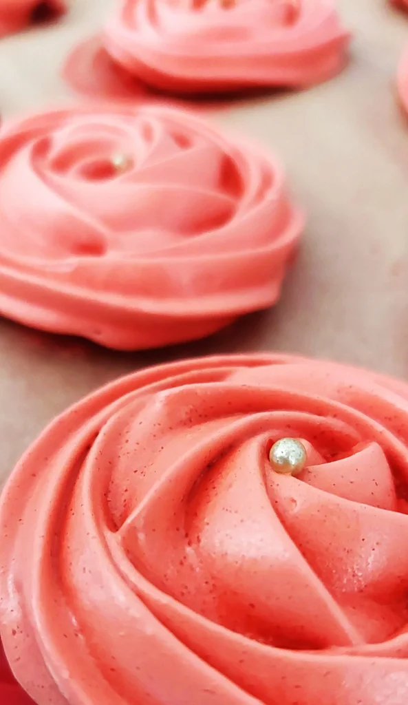Des meringues roses sur un plateau