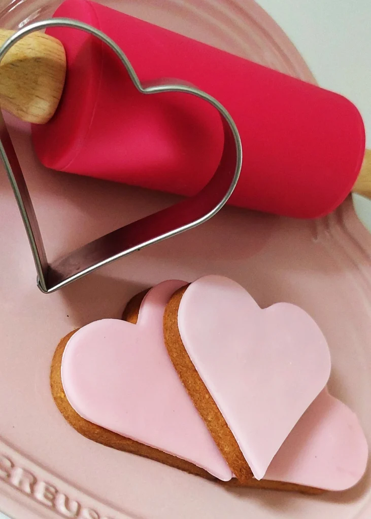 Des biscuits en forme de coeurs roses avec un rouleau à patisserie rose - pâtisseries artisanales à Troyes